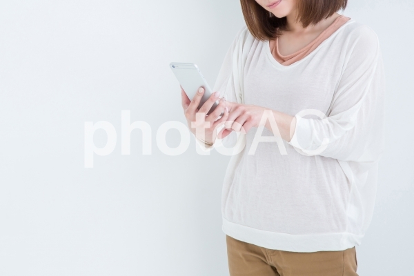 電話を持って考える女性 電話を持って考える女性の写真