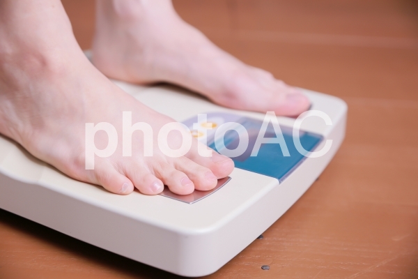 体重計に乗る女性 体重計に乗る女性の写真