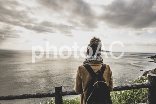 海を眺める女性の後ろ姿 海を眺める女性の後ろ姿の写真