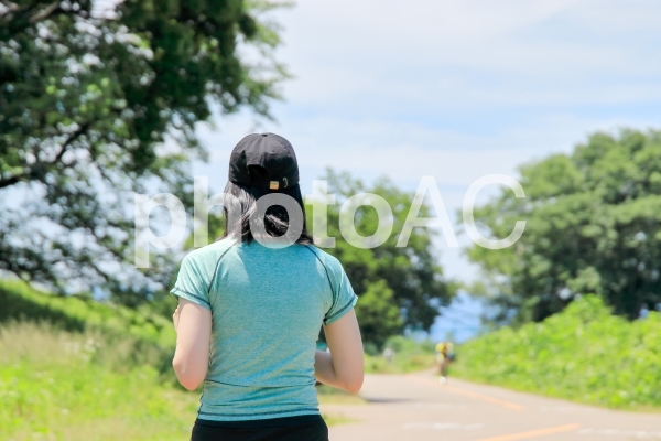 ランニングキャップを被って走る女性 ランニングキャップを被って走る女性の写真