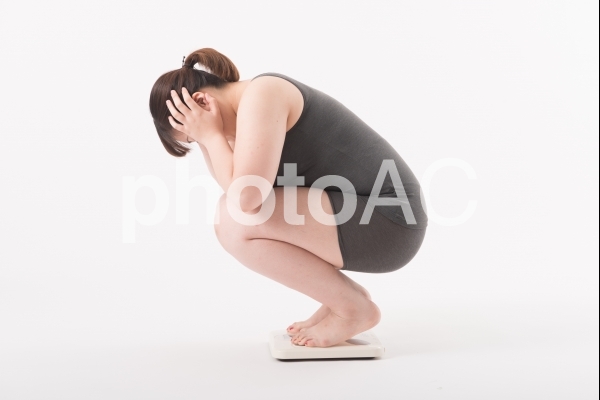 体重計にのり困っている女性2 体重計にのり困っている女性2の写真