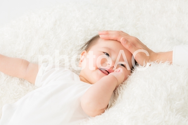 女性に撫でられる赤ちゃん(笑顔) 女性に撫でられる赤ちゃん(笑顔)の写真