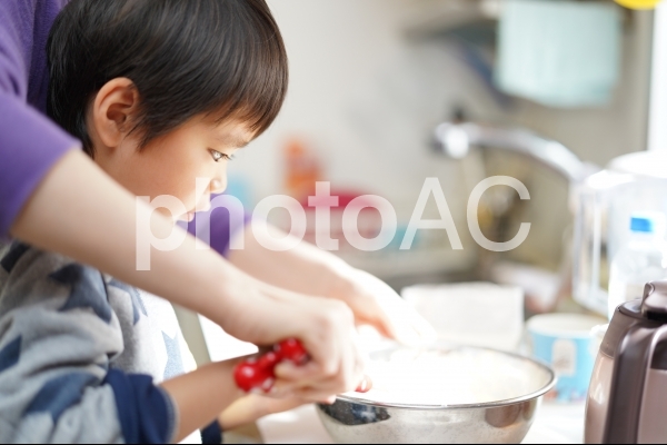 おうち時間中にパンケーキ作りのお手伝いをする子ども おうち時間中にパンケーキ作りのお手伝いをする子どもの写真