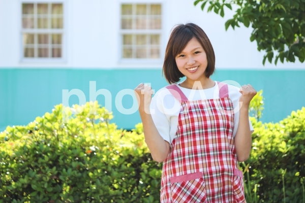 ガッツポーズのエプロン姿の女性 ガッツポーズのエプロン姿の女性の写真