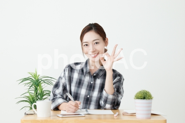 メモをしながらOKサインで笑顔の女性 メモをしながらOKサインで笑顔の女性の写真