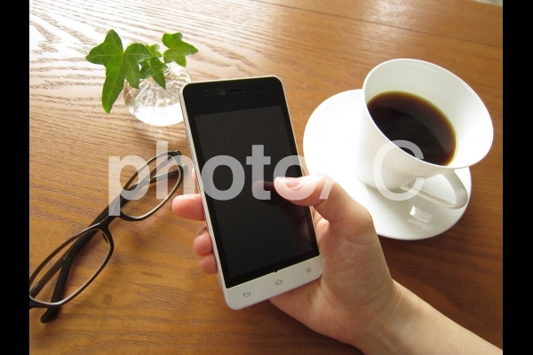 スマートフォンを持つ手 スマートフォンを持つ手の写真