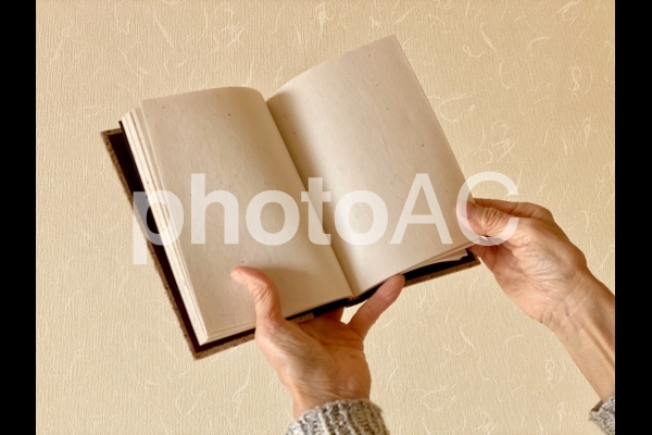 本のページをめくる高齢者の手 本のページをめくる高齢者の手の写真
