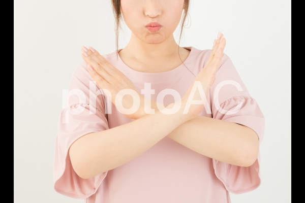 バツサインする女性 バツサインする女性の写真