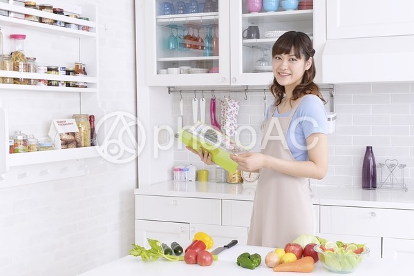 キッチンでレシピを見る女性3 キッチンでレシピを見る女性3の写真