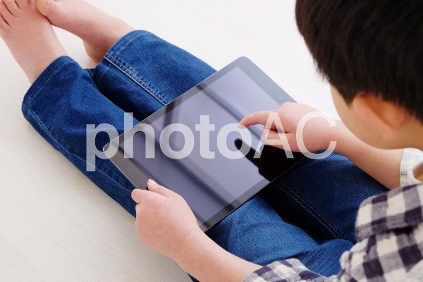 タブレットを使う男の子 タブレットを使う男の子の写真