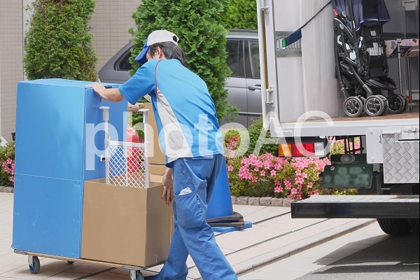 荷台で荷物を運ぶ引越しスタッフ 荷台で荷物を運ぶ引越しスタッフの写真