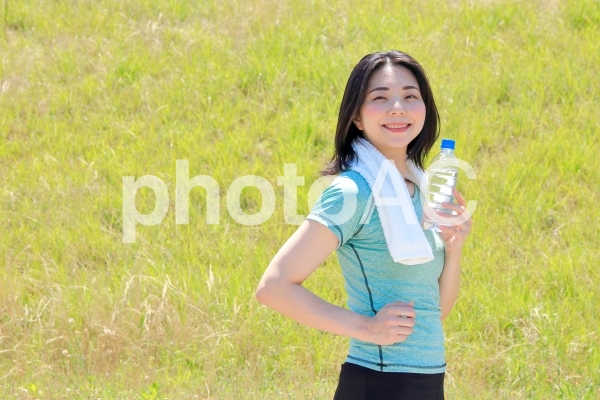水分補給とスポーツをする女性 水分補給とスポーツをする女性の写真
