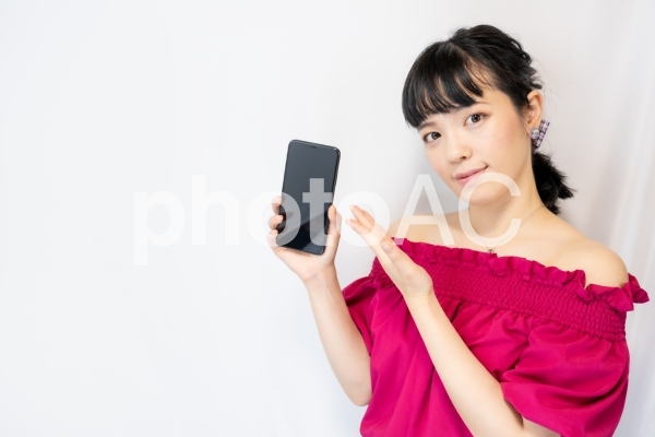 スマホを手で示す女性(白背景) スマホを手で示す女性(白背景)の写真