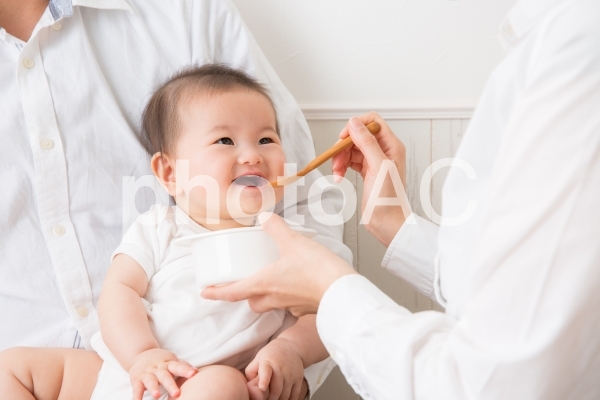 離乳食を食べる赤ちゃん(笑顔) 離乳食を食べる赤ちゃん(笑顔)の写真