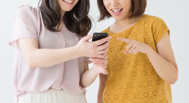 スマホを見て喜ぶ女性