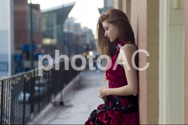 壁に寄りかかる赤いドレスの女性2 壁に寄りかかる赤いドレスの女性2の写真