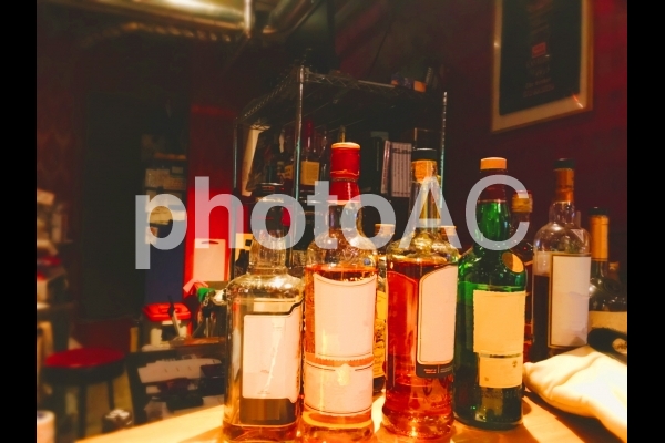 バーカウンターに並んだ酒瓶 バーカウンターに並んだ酒瓶の写真