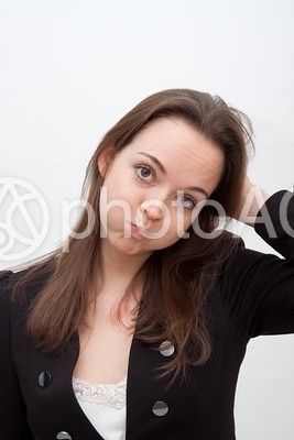 頭を触って口を膨らませる女性 頭を触って口を膨らませる女性の写真