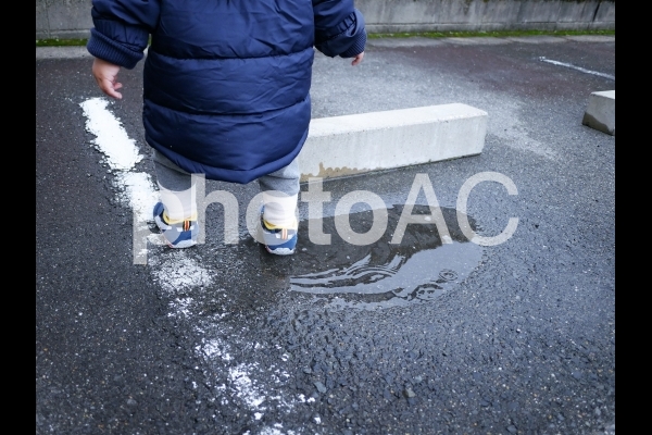 水たまりで遊ぶこども 水たまりで遊ぶこどもの写真