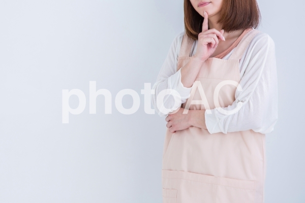 アイディアを思い浮かべるエプロン姿の女性 アイディアを思い浮かべるエプロン姿の女性の写真