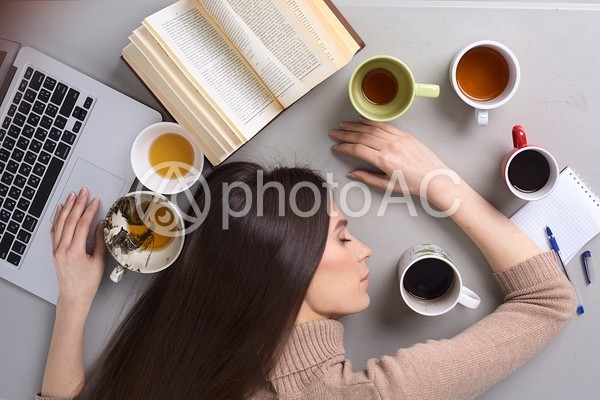 机に伏せて眠る女性9 机に伏せて眠る女性9の写真