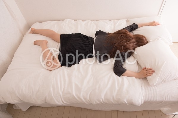 ベッドに倒れる女性1 ベッドに倒れる女性1の写真