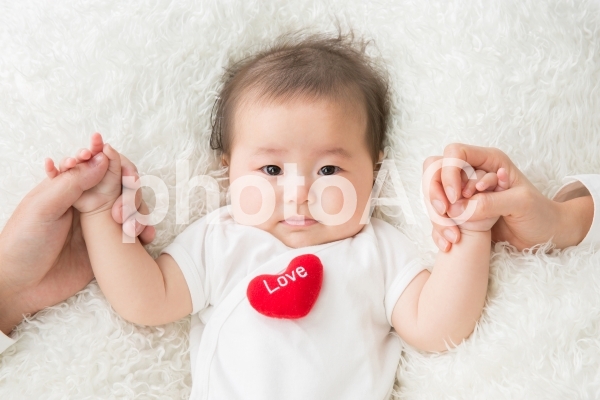 両親と手をつなぐ赤ちゃん(涙) 両親と手をつなぐ赤ちゃん(涙)の写真