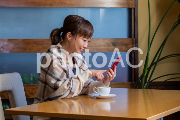 レストランでスマホを見る女性 レストランでスマホを見る女性の写真