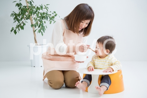 離乳食を食べさせる女性 離乳食を食べさせる女性の写真