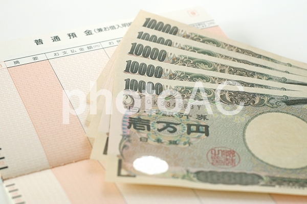 通帳と一万円札 通帳と一万円札の写真