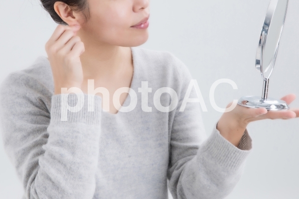 耳を触る女性 耳を触る女性の写真