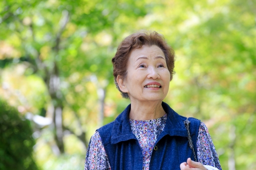 自然の中を歩くシニア女性の写真