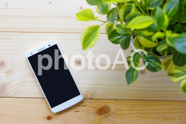 木材の上に置かれたスマートフォン 木材の上に置かれたスマートフォンの写真