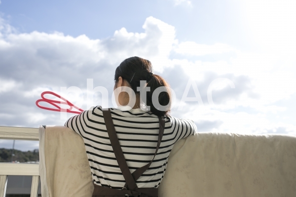 布団を干す女性 布団を干す女性の写真