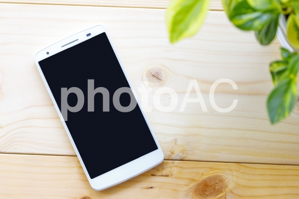 木材の上に置かれたスマートフォン 木材の上に置かれたスマートフォンの写真