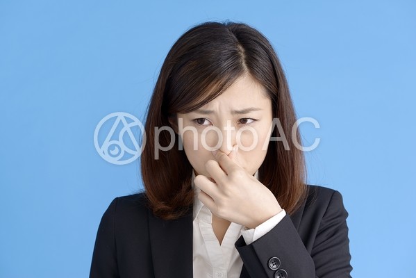 鼻をつまむ女性 鼻をつまむ女性の写真