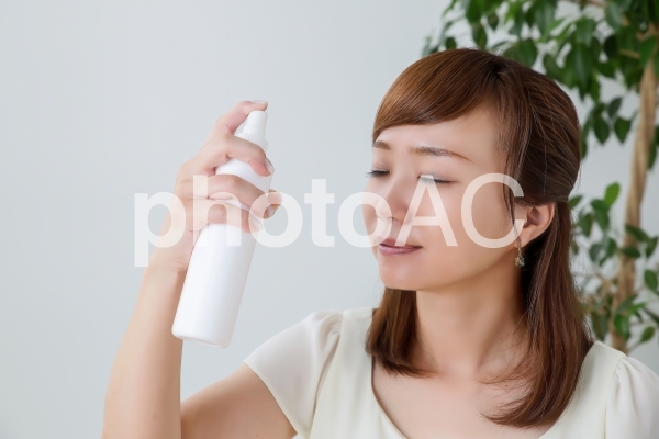 ミスト化粧水をかける女性 ミスト化粧水をかける女性の写真