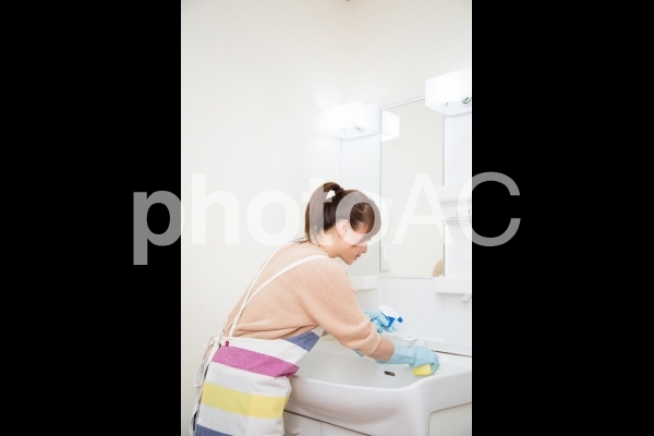 洗面台を掃除する女性(シンク) 洗面台を掃除する女性(シンク)の写真