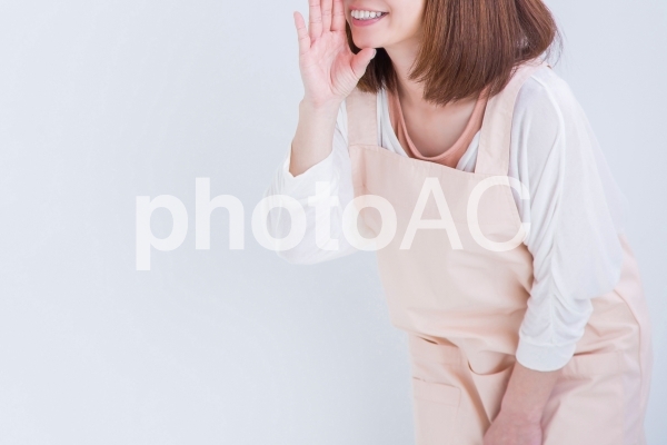 なにかを伝えるエプロン姿の女性 なにかを伝えるエプロン姿の女性の写真