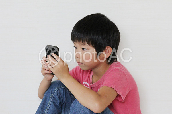 スマホで遊ぶ男の子 スマホで遊ぶ男の子の写真
