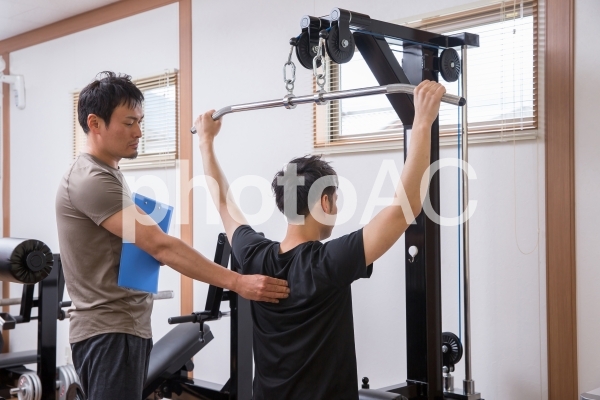 パーソナルトレーニングを受ける男性 パーソナルトレーニングを受ける男性の写真