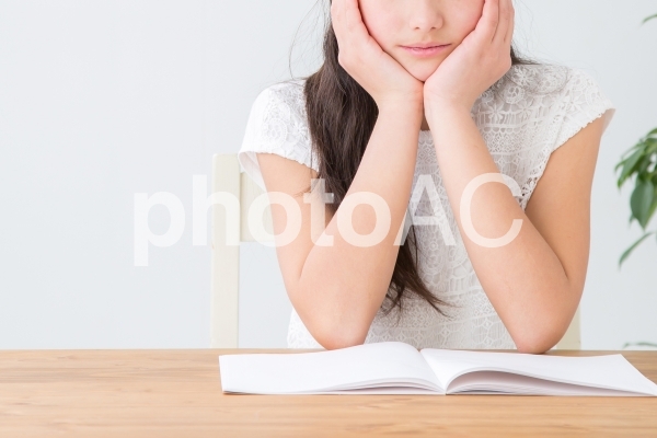 机で勉強する女の子 机で勉強する女の子の写真