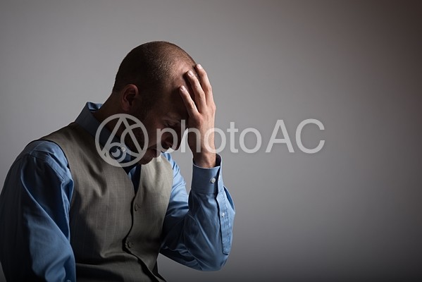 頭を抱える外国人男性 頭を抱える外国人男性の写真