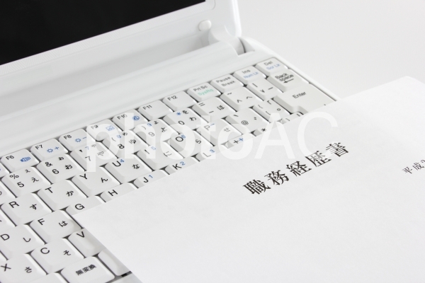 パソコンと書類 パソコンと書類の写真