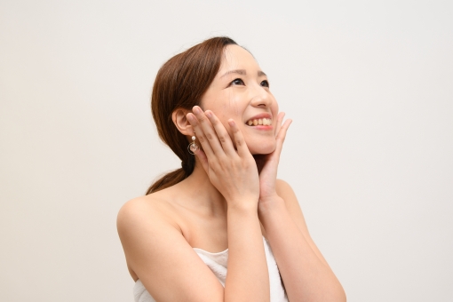 肌の調子がいいと喜ぶ女性の写真