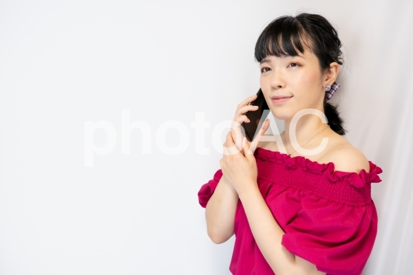 スマホで通話する女性(白背景) スマホで通話する女性(白背景)の写真