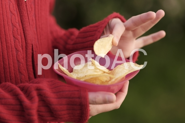 ポテトチップスを食べる女性の手元3 ポテトチップスを食べる女性の手元3の写真