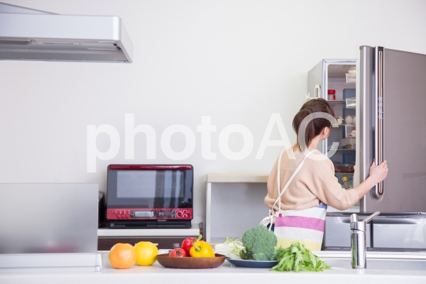 冷蔵庫を見る女性 冷蔵庫を見る女性の写真