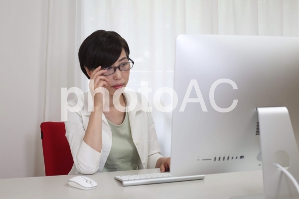 パソコンで仕事をする女性 パソコンで仕事をする女性の写真