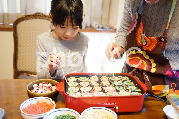 たこ焼き作りを手伝う女の子 たこ焼き作りを手伝う女の子の写真